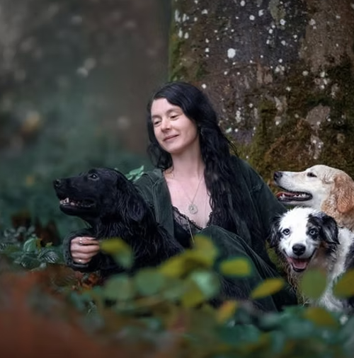 Manuela Zihlmann mit ihren Hunden vor einem alten Baum im Wald